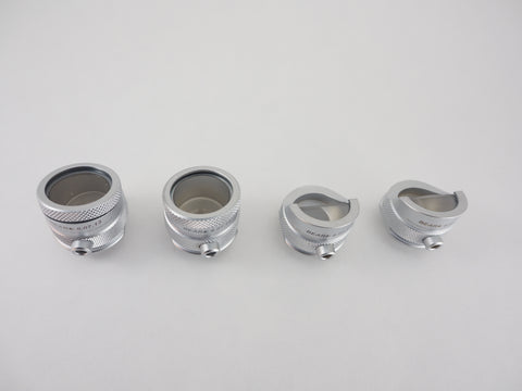 Top view of four different Bruening head diagnostic lenses. Both half lens and full lens that are magnified and non-magnified